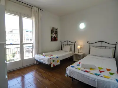a bedroom with two beds and a large window at Clarimar Sky Blue by Hello Homes Sitges in Sitges