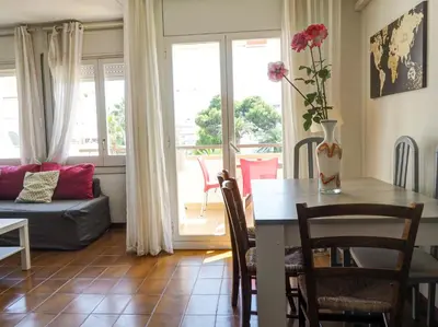 a living room with a table with a vase of flowers at Clarimar Sky Blue by Hello Homes Sitges in Sitges