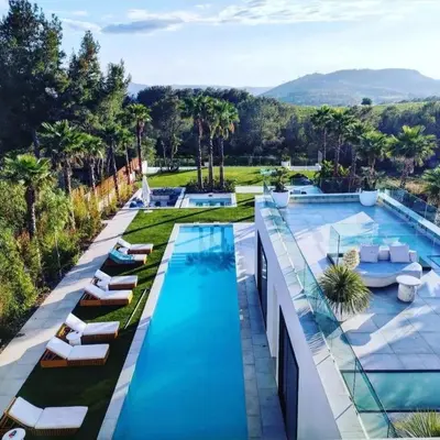 an image of a swimming pool with lounge chairs and palm trees at Contemporary villa near Sitges Hills in Avinyonet