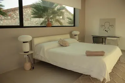 a bedroom with a bed and a palm tree at Contemporary villa near Sitges Hills in Avinyonet