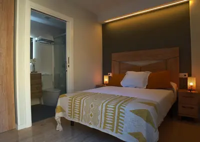 a bedroom with a large bed and a bathroom at Can Mir Badalona in Badalona
