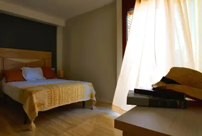 a bedroom with a bed and a window at Can Mir Badalona in Badalona