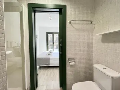 a bathroom with a green door leading to a bedroom at Click&Flat Fontanella in Barcelona