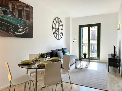 a dining room and living room with a table and chairs at Click&Flat Fontanella in Barcelona