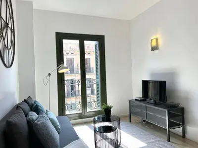 a living room with a couch and a tv at Click&Flat Fontanella in Barcelona