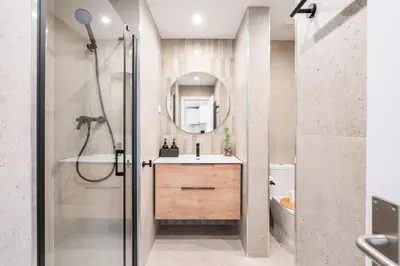 a bathroom with a sink and a shower with a mirror at Lodging Apartments Liceu G1 in Barcelona