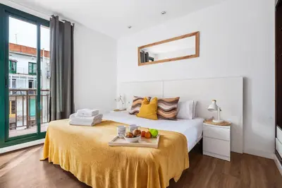 a bedroom with a bed with a tray of fruit on it at Lodging Apartments Liceu G1 in Barcelona
