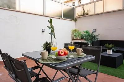 a table with a bowl of fruit and two glasses of orange juice at Lodging Apartments Liceu 11 in Barcelona