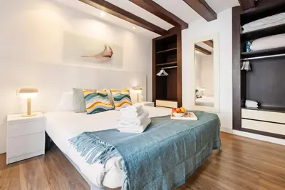 a bedroom with a bed with a blue blanket at Lodging Apartments Liceu 11 in Barcelona