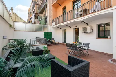 an apartment patio with tables and chairs and plants at Lodging Apartments Liceu 11 in Barcelona