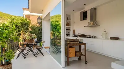 a white balcony with white chairs and a table at Villa Sitges Colonial. Impressive views of the sea. High design. Renovated. in Sitges