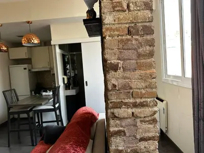 a living room with a brick wall and a couch at Nice apartment close to park Guell1 in Barcelona