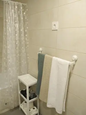 a bathroom with white towels on a towel rack at Family Apartment in Vilanova i la Geltrú
