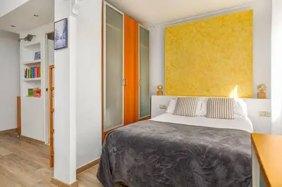 a bedroom with a bed and a yellow wall at Estudio Bogatell Beach Se admiten mascotas AC in Barcelona