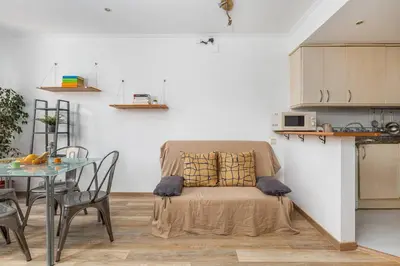 a living room with a table and a chair with a pillow at Estudio Bogatell Beach Se admiten mascotas AC in Barcelona