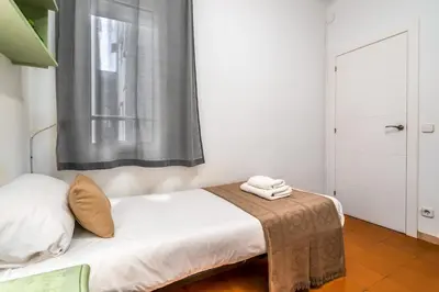 a small bedroom with a bed with a window at Arc de Triomf Base 4BR for 5 Lift in Barcelona