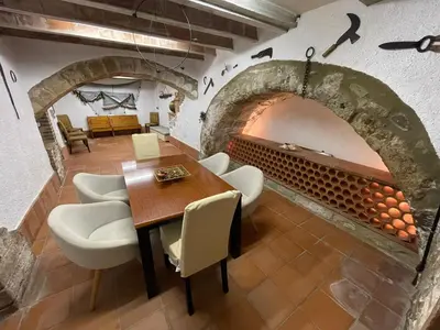 a dining room with a table and a fireplace at Molí den burch in Santa Eulalia de Ronsaná