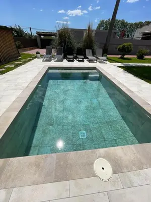 a swimming pool with turquoise water in a yard at Molí den burch in Santa Eulalia de Ronsaná