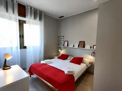 a bedroom with a large bed with red pillows at Fira Plaza España apartment in Barcelona