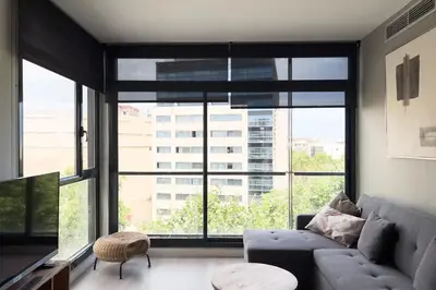 a living room with a couch and a large window at ChicStays Apartment Vila Olímpica in Barcelona