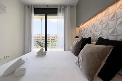 a bedroom with a white bed with a large window at ChicStays Apartment Vila Olímpica in Barcelona