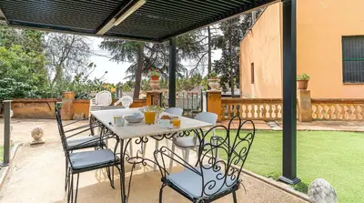 a patio with a table and chairs on a deck at Casa Can Roura in Vilassar de Dalt