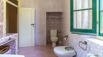 a bathroom with a toilet and a window at Casa Can Roura in Vilassar de Dalt