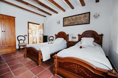 two beds in a room with white walls at Masia Can Viver - Olive oil tourism B&B in Bigues i Riells