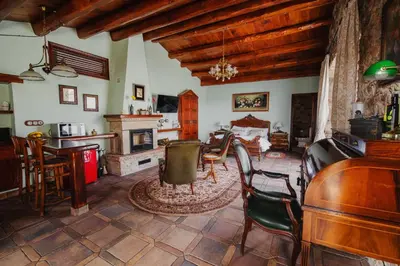 a living room with chairs and a table and a fireplace at Masia Can Viver - Olive oil tourism B&B in Bigues i Riells