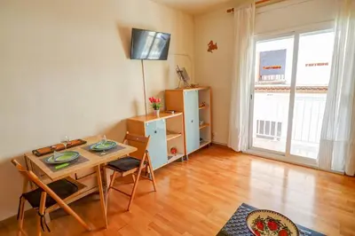 a living room with a table and a dining room at Hermione Apartment by Hello Homes Sitges in Sitges