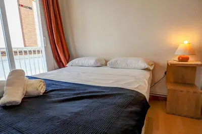 a bedroom with two twin beds and a window at Hermione Apartment by Hello Homes Sitges in Sitges