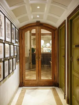 a wooden door in a hallway with pictures on the walls at Hotel Astoria in Barcelona