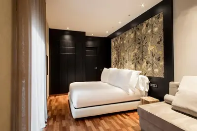 a living room with a white chair and a couch at Claris Hotel & Spa GL, a Small Luxury Hotel of the World in Barcelona