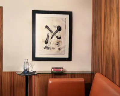 a picture hanging on a wall with a table and a picture at Hotel Gran Derby Suites, a Small Luxury Hotel of the World in Barcelona