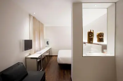 a bedroom with a bed and a couch and a mirror at Hotel Balmes, a member of Preferred Hotels & Resorts in Barcelona