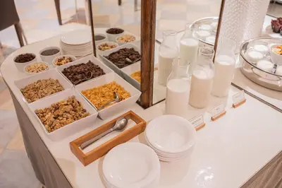 a table topped with white plates and containers of food at Hotel Derby in Barcelona
