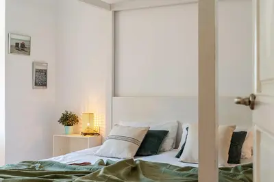 a white bedroom with a bed with pillows at Canela Homes BARCELONA CASP in Barcelona