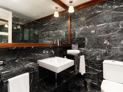 a black marble bathroom with a sink and a toilet at U232 Hotel in Barcelona