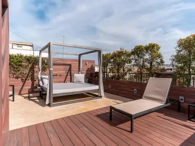 a gazebo on a deck with a bed and a chair at U232 Hotel in Barcelona