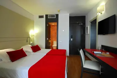 a hotel room with a large bed and a desk at Grupotel Gravina in Barcelona