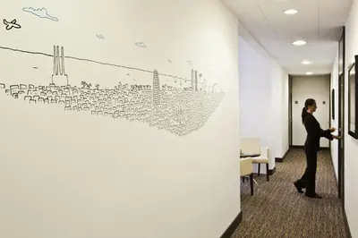 a man standing in an office with a drawing on a wall at Grupotel Gravina in Barcelona
