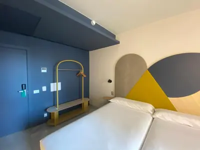 a bedroom with a bed with a yellow and blue wall at Onix Fira in Barcelona