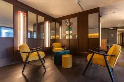 a waiting room with yellow chairs and tables at Onix Fira in Barcelona