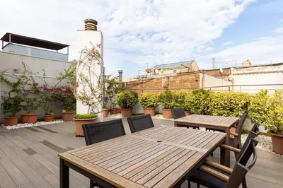 a wooden table and chairs on a rooftop patio at Onix Fira in Barcelona