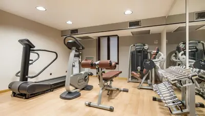 a gym with treadmills and elliptical machines at Ilunion Almirante in Barcelona