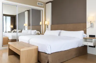 a large bedroom with two beds and a mirror at Guitart Grand Passage in Barcelona