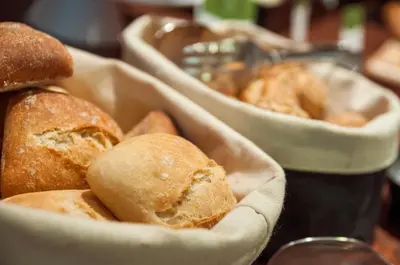 a group of breads in baskets on a table at Exe Mitre in Barcelona