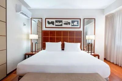 a bedroom with a large white bed and two lamps at Exe Parc del Vallés in Cerdanyola del Valles