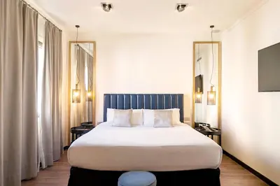 a bedroom with a large bed and two windows at La França Travellers in Barcelona