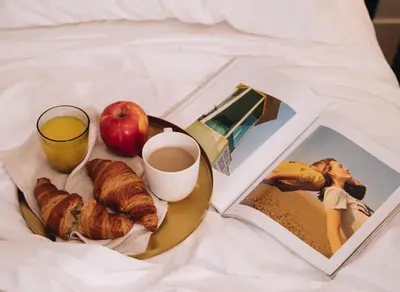 a breakfast plate with an apple and a cup of coffee and a book at H La Paloma Boutique in Barcelona